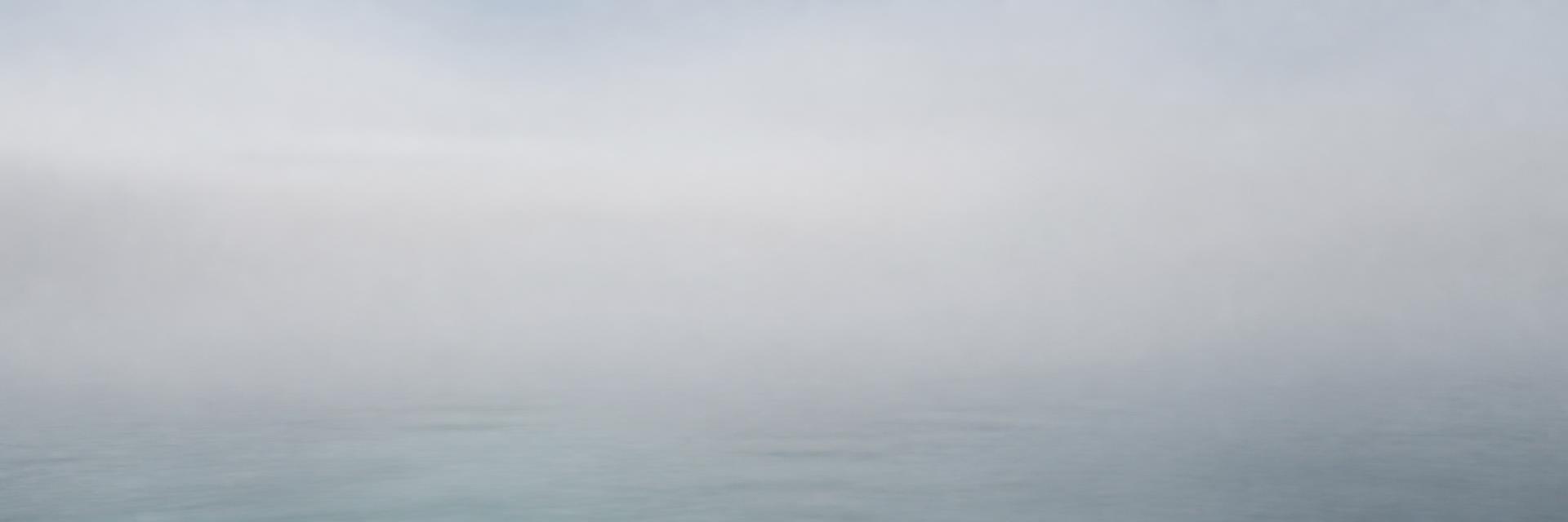 A soft, almost abstract horizon line where pale sea meets pale sky